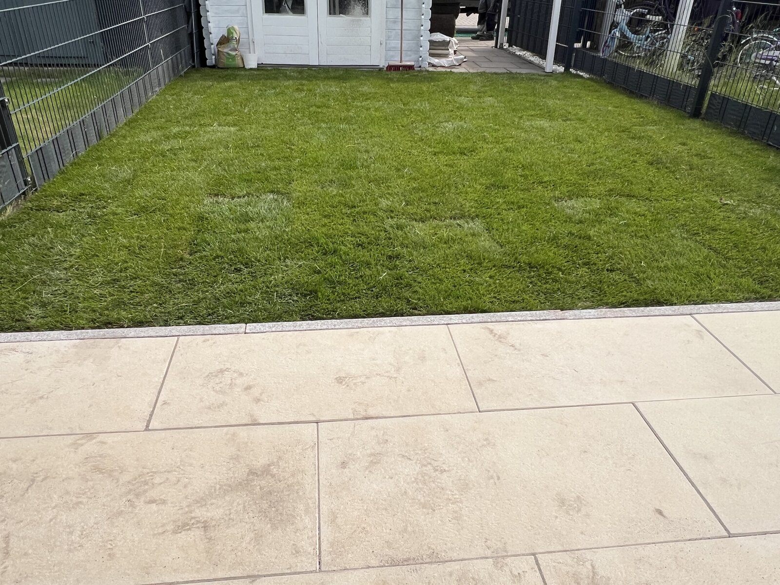 Neue Terrasse mit hellen Platten und Rollrasen in Bremen Arsten
